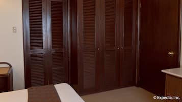 Una camera da letto con un letto, un armadio in legno e un comodino.