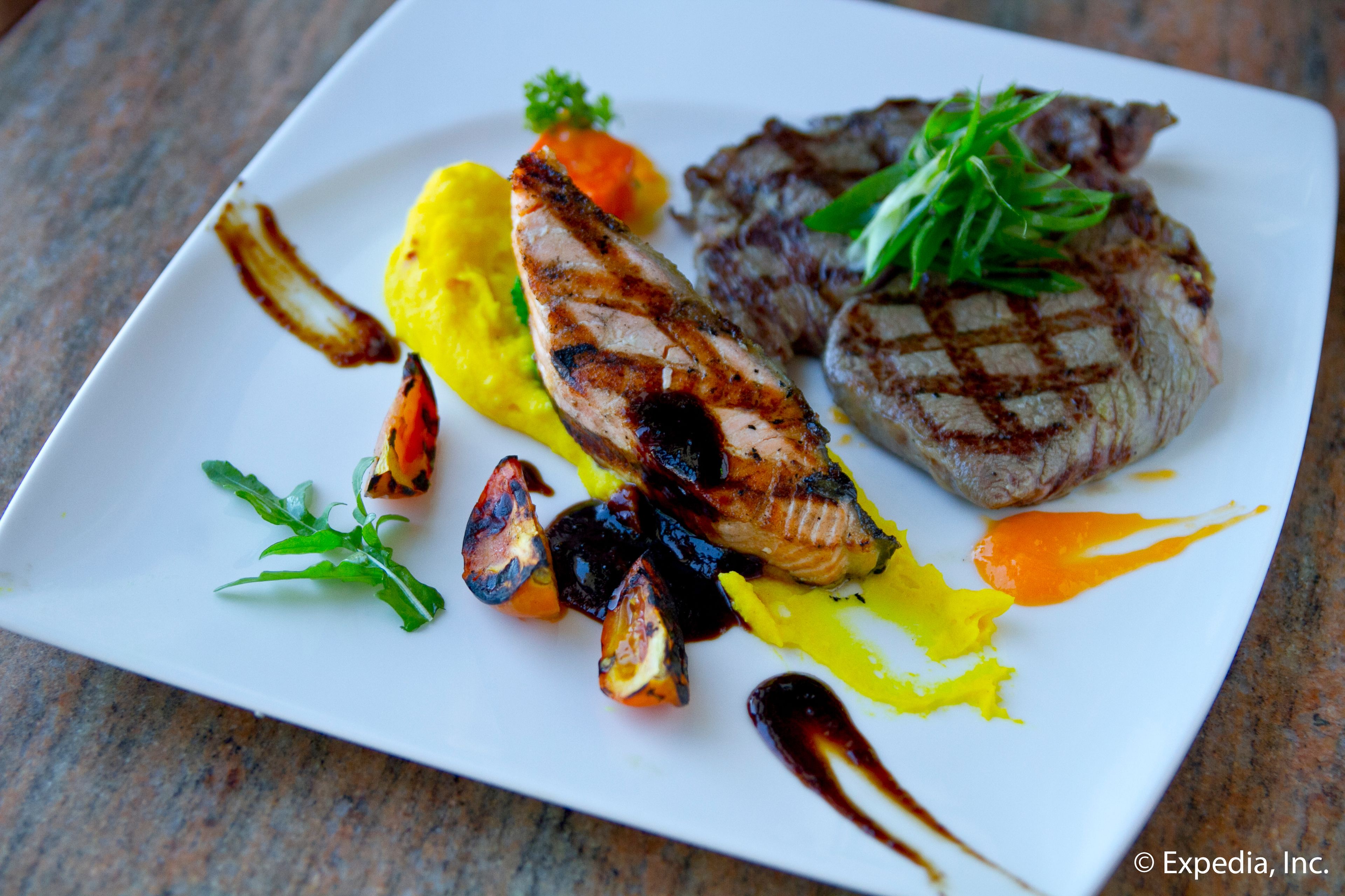 A plate of grilled meat with vegetables and sauce.