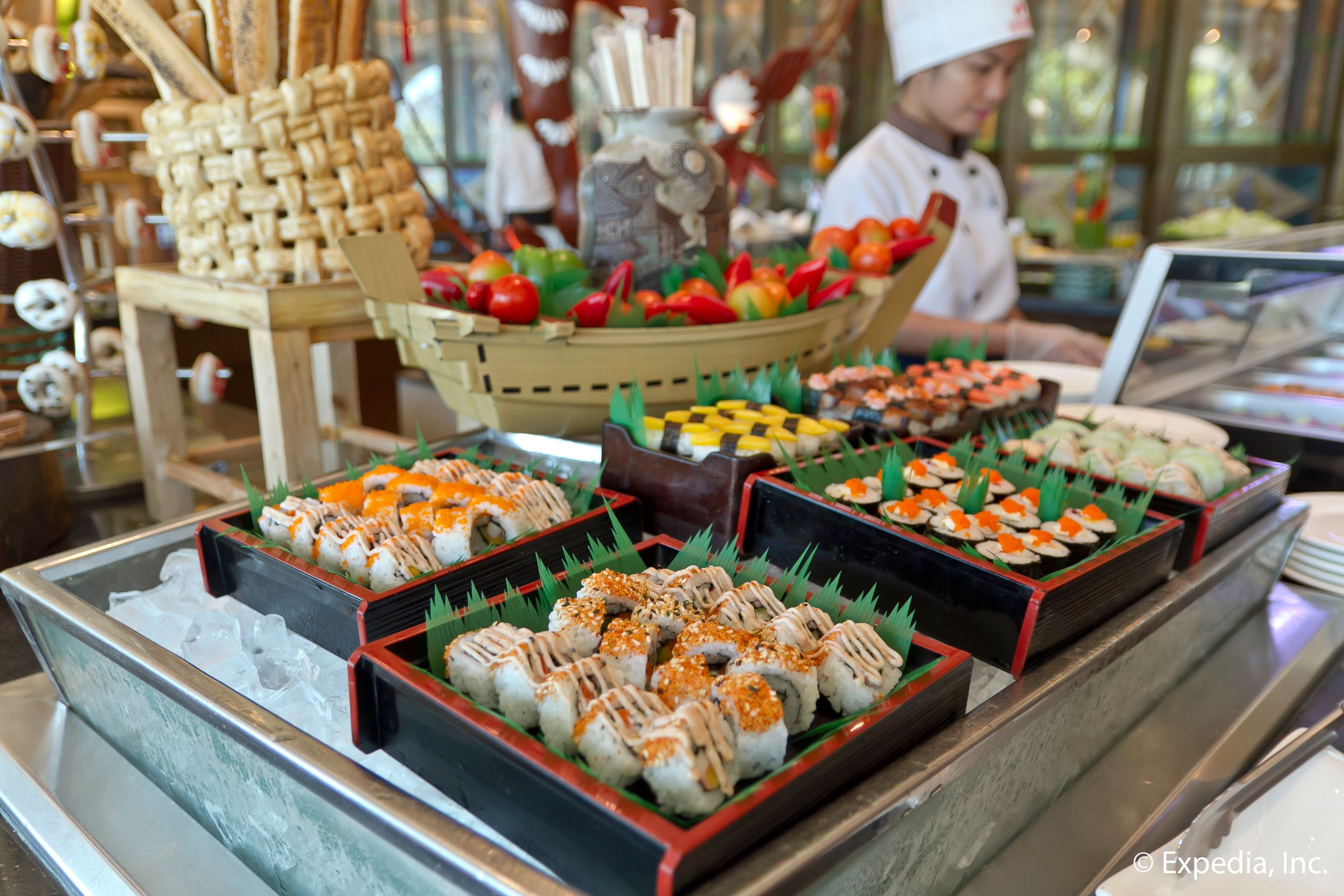 A buffet with various sushi and sashimi dishes, arranged in trays and baskets.