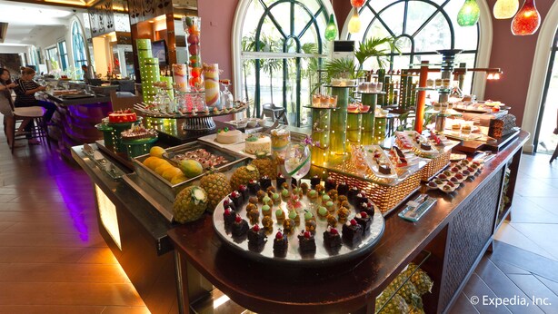 A buffet with various food items and drinks, a bar area, and a seating section with tables and chairs.