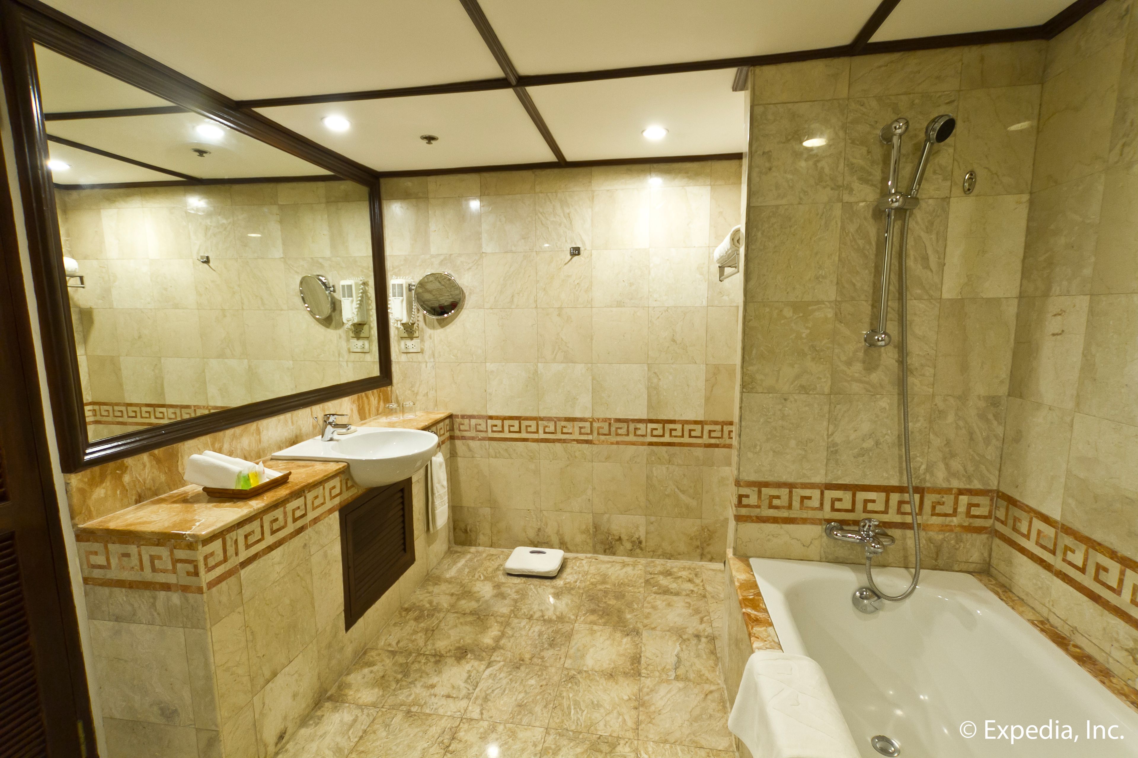 Un baño con piso de mármol, un lavamanos, un espejo, una ducha y una balanza.