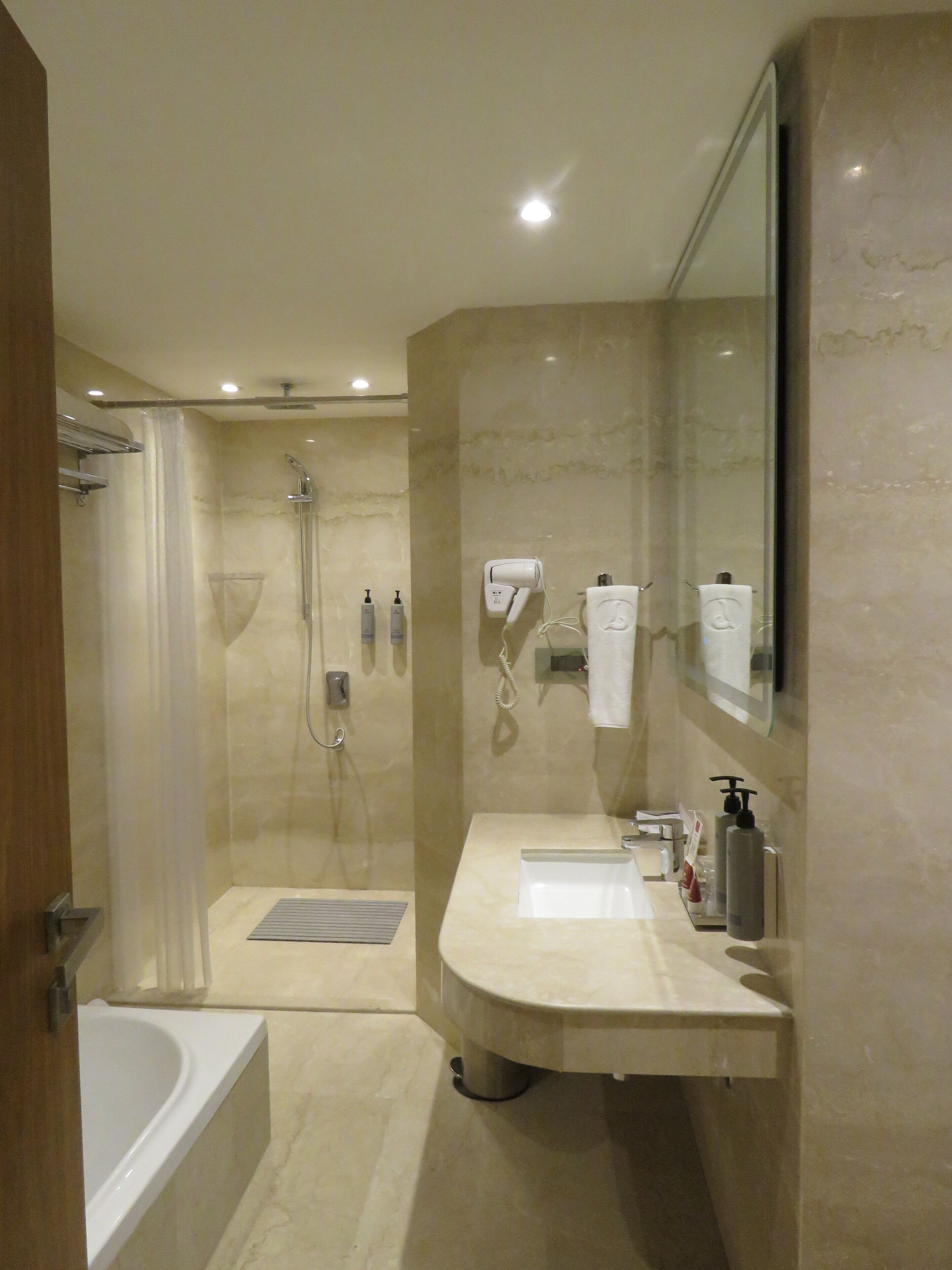 Un baño moderno con bañera, ducha y tocador con espejo.