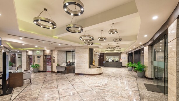 A spacious lobby with a marble floor, a reception desk, and modern circular ceiling lights. - Lords Plaza, Surat (Surat)