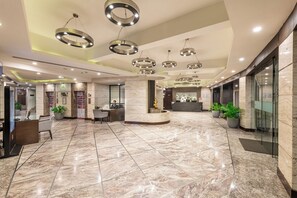 A spacious lobby with a marble floor, a reception desk, and modern circular ceiling lights. - Lords Plaza, Surat (Surat)