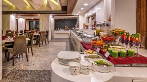 A buffet setup with various food items and beverages, a marble floor, and a modern ceiling design. - Lords Plaza, Surat (Surat)