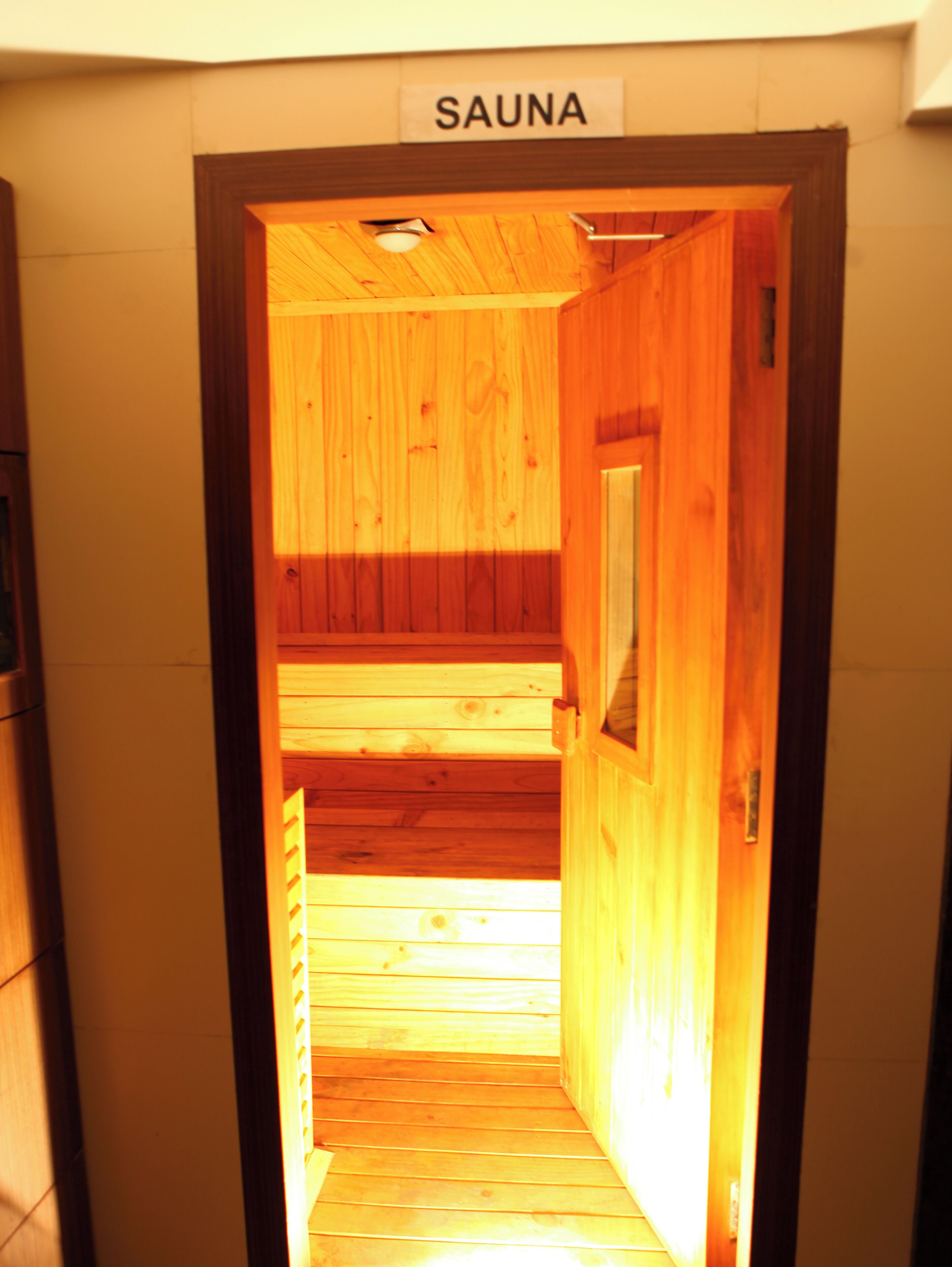 A wooden sauna entrance with a sign labeled "SAUNA".