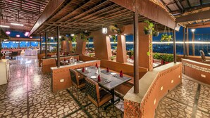 A restaurant with outdoor seating, stone flooring, and hanging plants. - Lords Plaza, Surat (Surat)