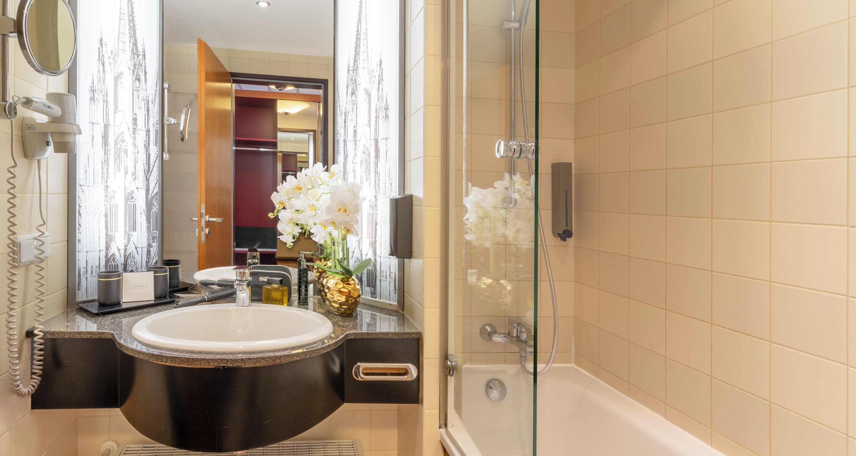 Een moderne badkamer met een grote spiegel, een wastafel en een douche.