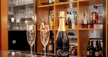 Una zona de bar con dos vasos vacíos y una botella de champán.