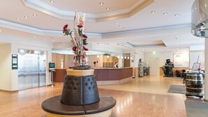 A spacious lobby with a central seating area, a reception desk, and a large decorative vase. - TOP martas Hotel Lutherstadt-Wittenberg (Lutherstadt Wittenberg)