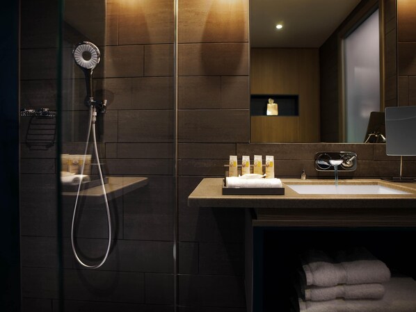 Un baño moderno con ducha, lavabo y espejo.