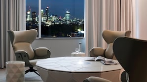 A modern hotel room with a large window offering a city view at night. - Pullman London St Pancras (London)