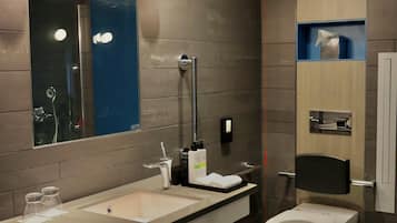A modern bathroom with a dual sink vanity, a toilet, and a large mirror.