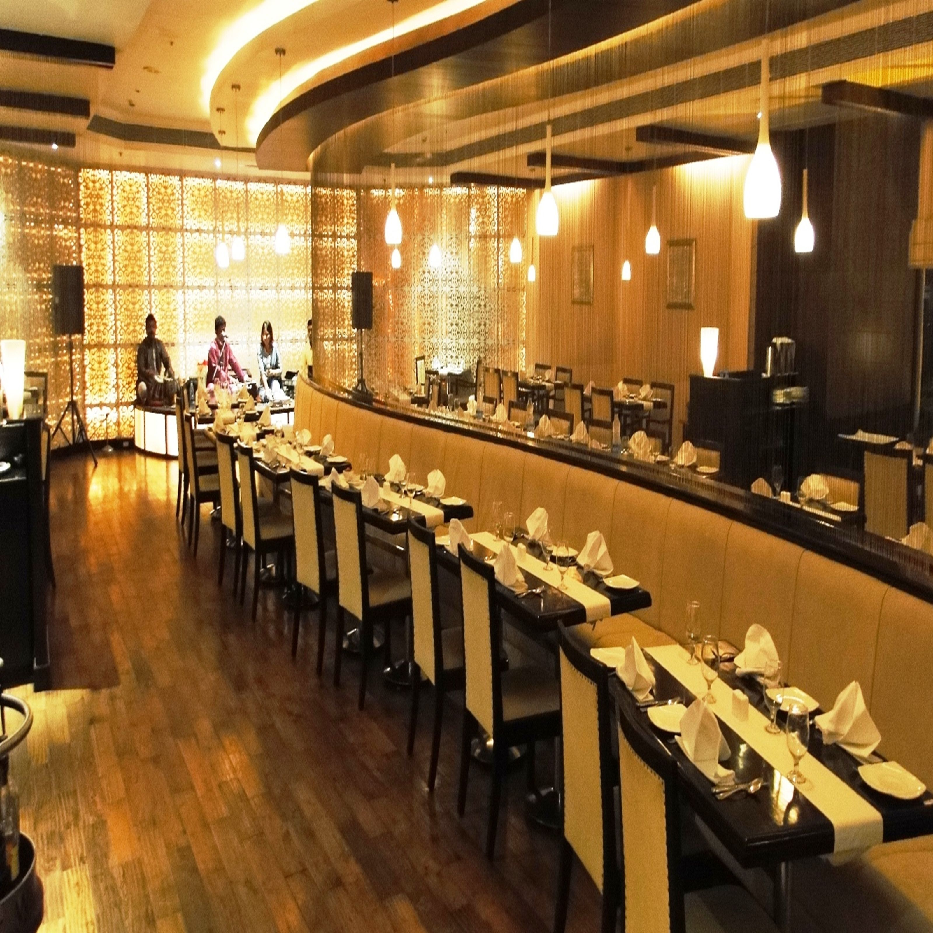 Un restaurant doté d’un long comptoir, de plusieurs tables et de chaises.