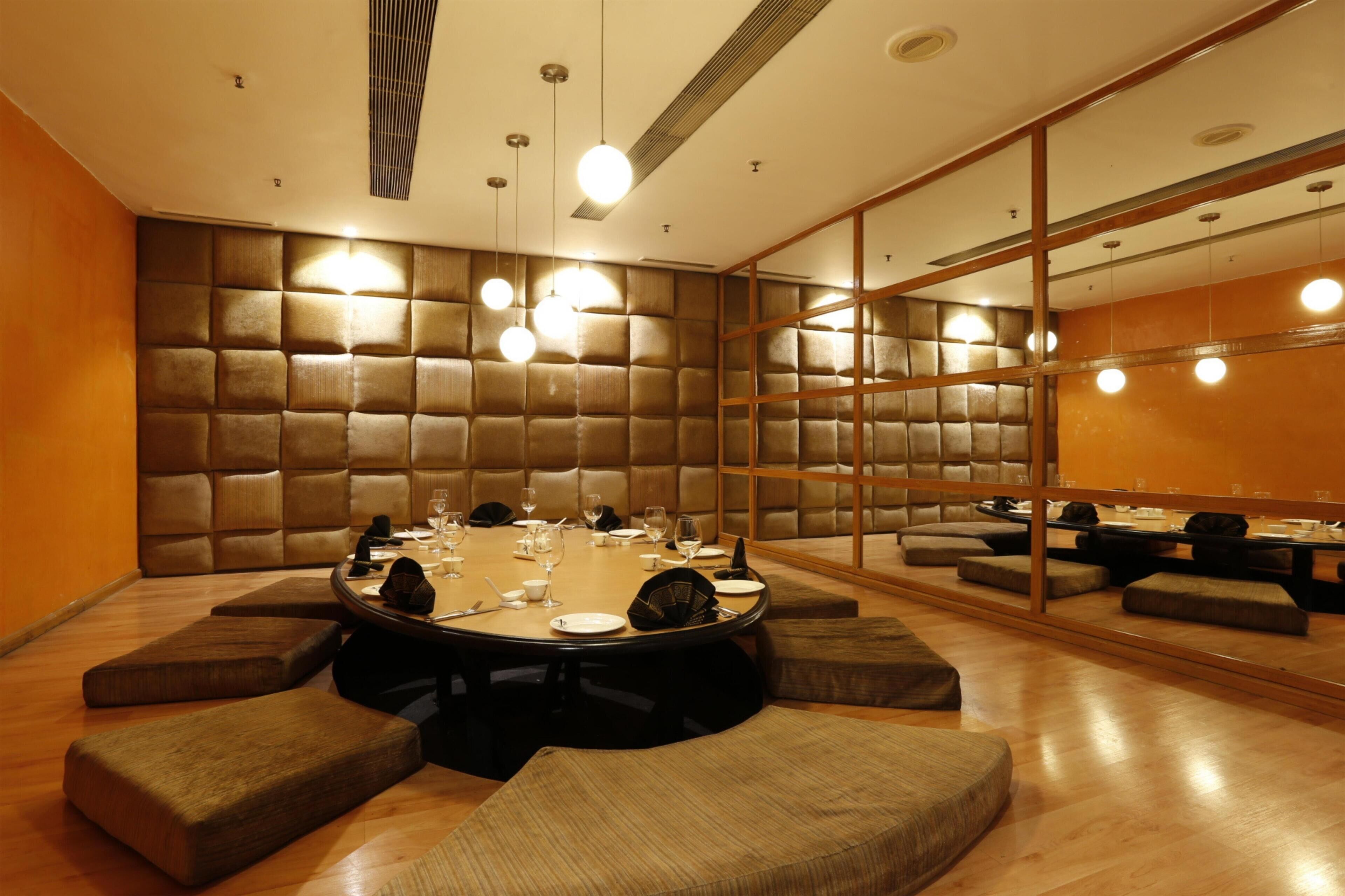 A conference room with a round table, cushioned seating, and a high-backed wall panel.