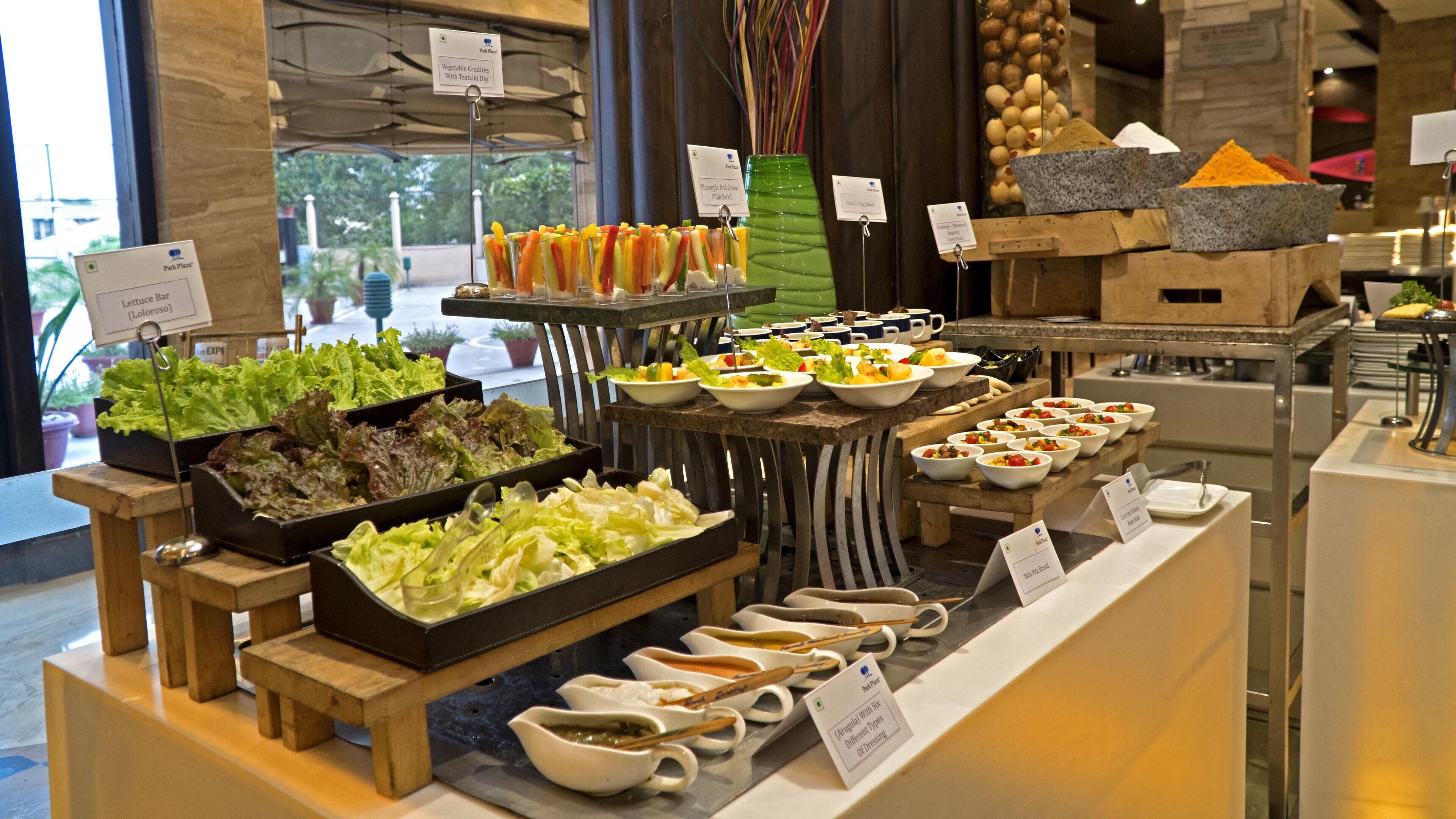 Een buffet met diverse keuzes, waaronder salades, dips en rijstgerechten.