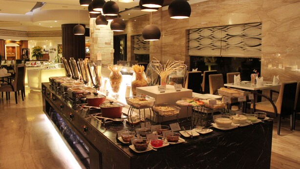 A buffet area with various food stations, a marble counter, and hanging pendant lights. - Park Plaza Ludhiana (Ludhiana)
