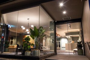 A modern hotel lobby with glass walls, a reception desk, and potted plants. - Pensione Hotel Perth (Perth)
