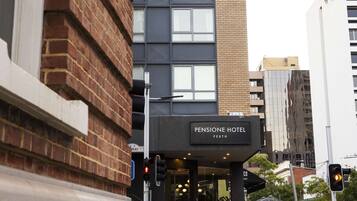 A building with a sign for 'Pensione Hotel' and a modern glass facade.