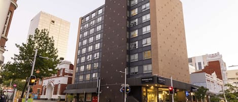A multi-story hotel with a modern design, featuring a prominent entrance and a visible name sign.