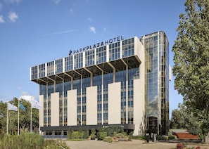 A modern hotel with a prominent name on the facade, large windows, and a flat roof.
