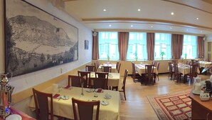 A spacious hotel dining area with multiple tables, a central serving station, and large windows providing natural light. - City Partner Hotel Holländer Hof (Heidelberg)