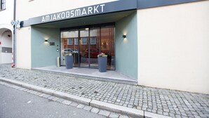 A storefront with the sign "AMJAKOBSMARKT" and large potted plants in front. - Hotel am Jakobsmarkt (Nuremberg)