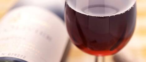Una botella de vino y una copa de vino con un sacacorchos.
