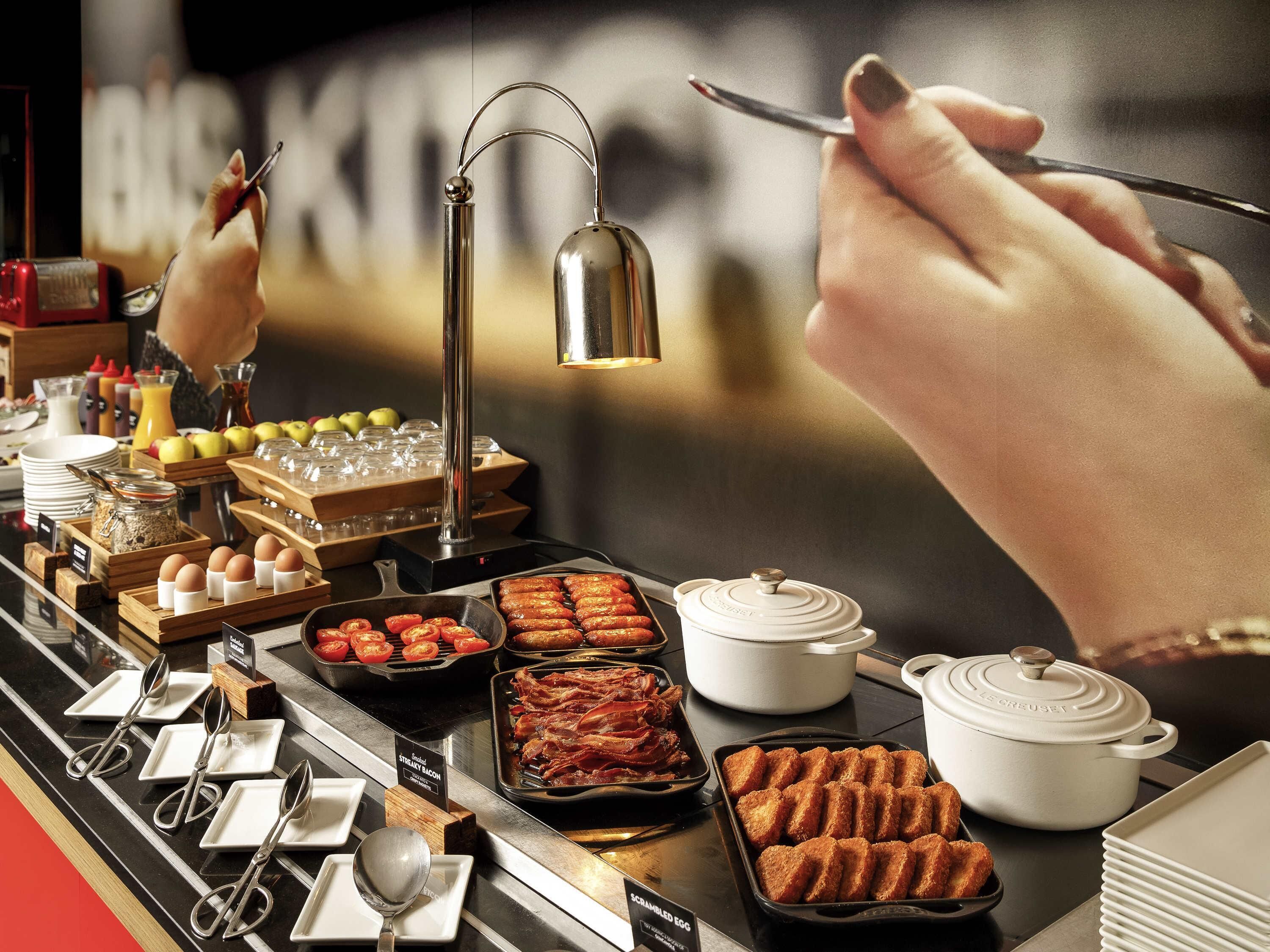 A buffet with various food items and utensils.