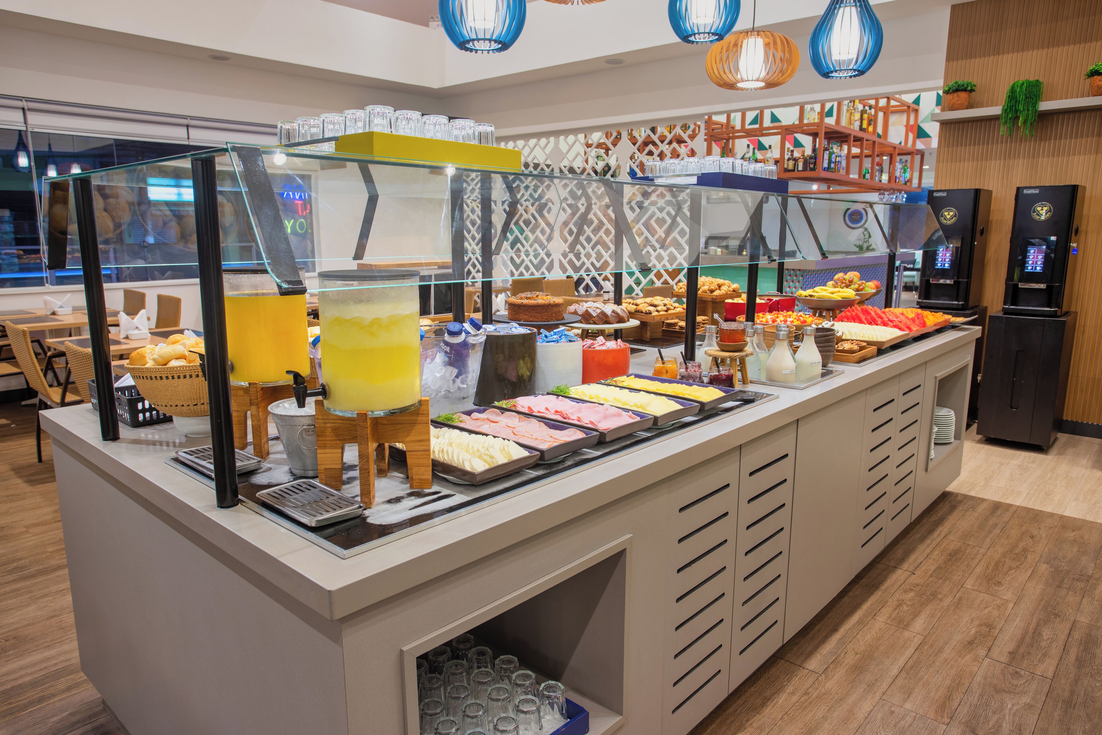 Een buffetgedeelte met diverse gerechten, een koffieapparaat en een koelkast.