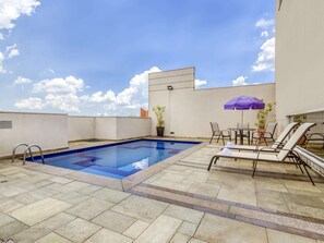 Una piscina al aire libre, tumbonas