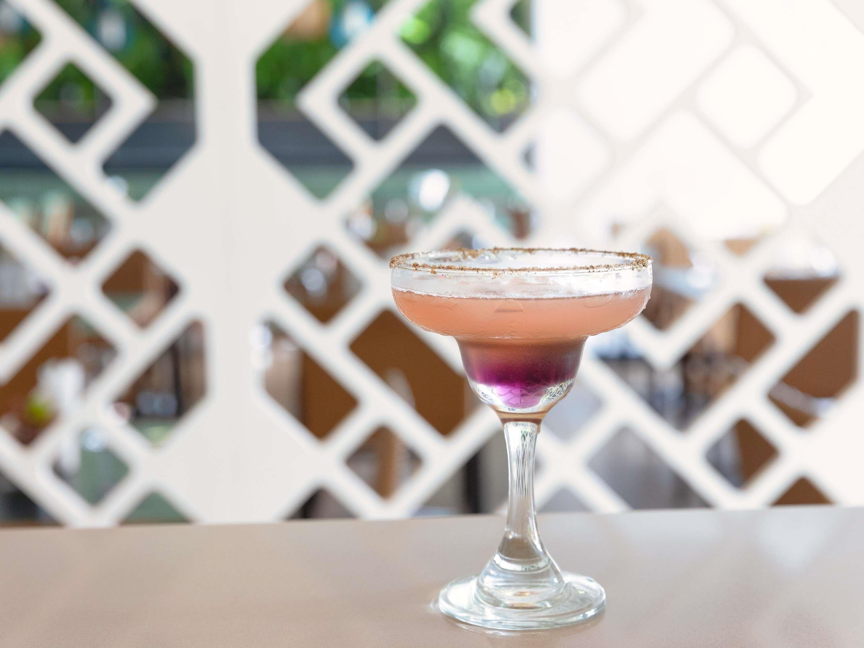 Um copo de cocktail com borda salgada sobre uma mesa.