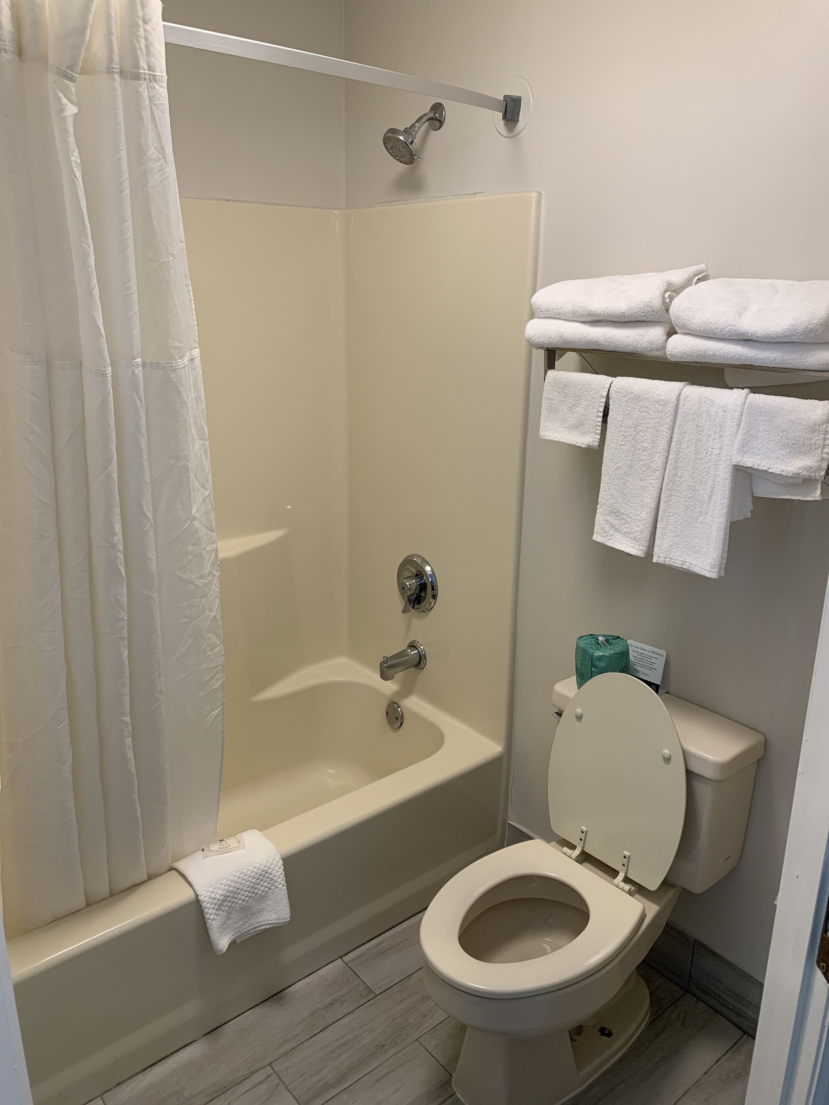 A bathroom with a bathtub, toilet, and shower.