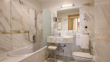 Un bagno con una vasca, un lavandino, un water e un bidet.