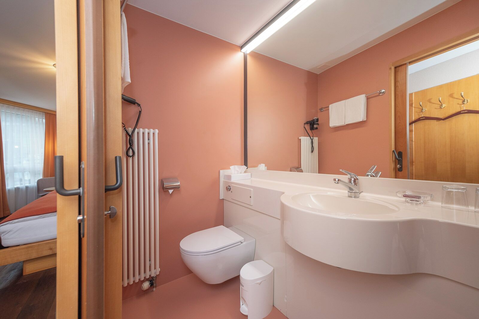 A modern bathroom with a large sink, a toilet, and a shower.