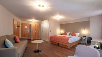 Une chambre d’hôtel avec un lit, un canapé, une petite table et un bureau.