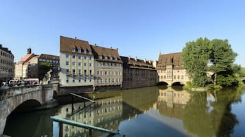 A historic European town with a river, stone bridges, and traditional buildings.