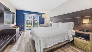 A modern hotel room with a large bed, a desk, a TV, and a balcony with a view. - Holiday Inn Express Sunnyvale - Silicon Valley by IHG (Sunnyvale)