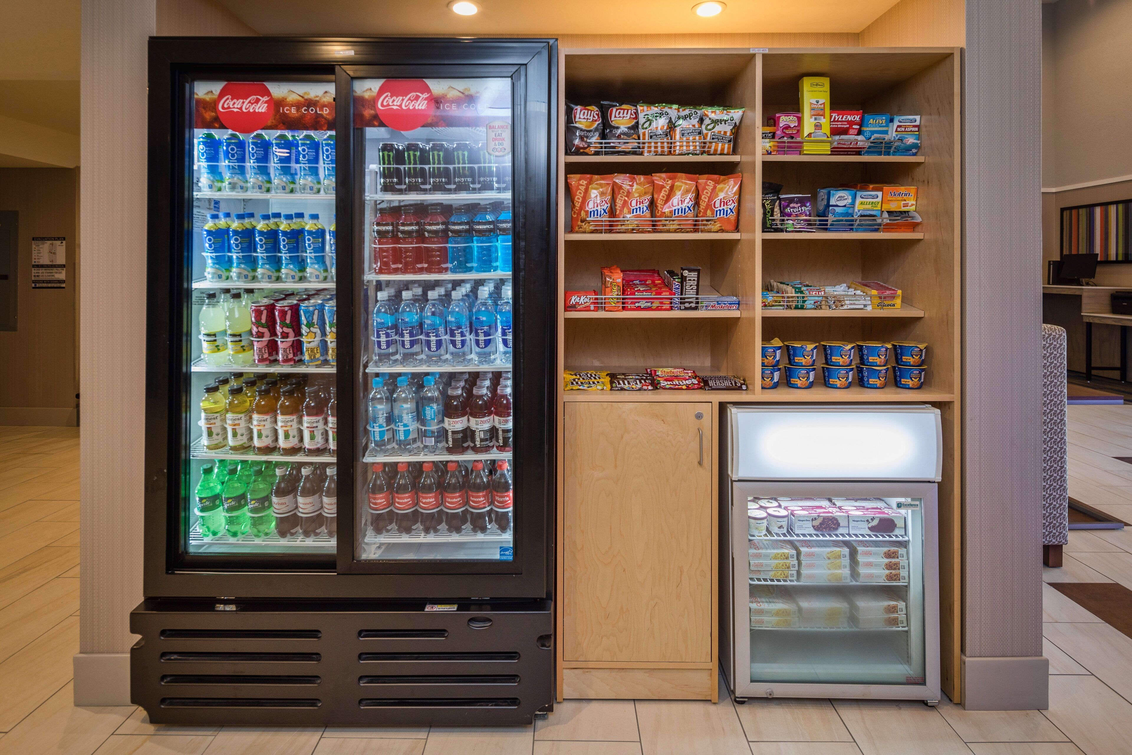 Ein Getränkeautomat mit einer Auswahl an Getränken und Snacks, darunter Coca-Cola, Lay's und Hershey's.