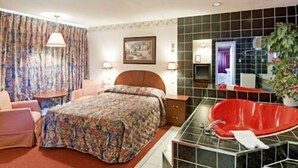 Habitación de hotel con cama, una bañera roja, una silla y un escritorio.