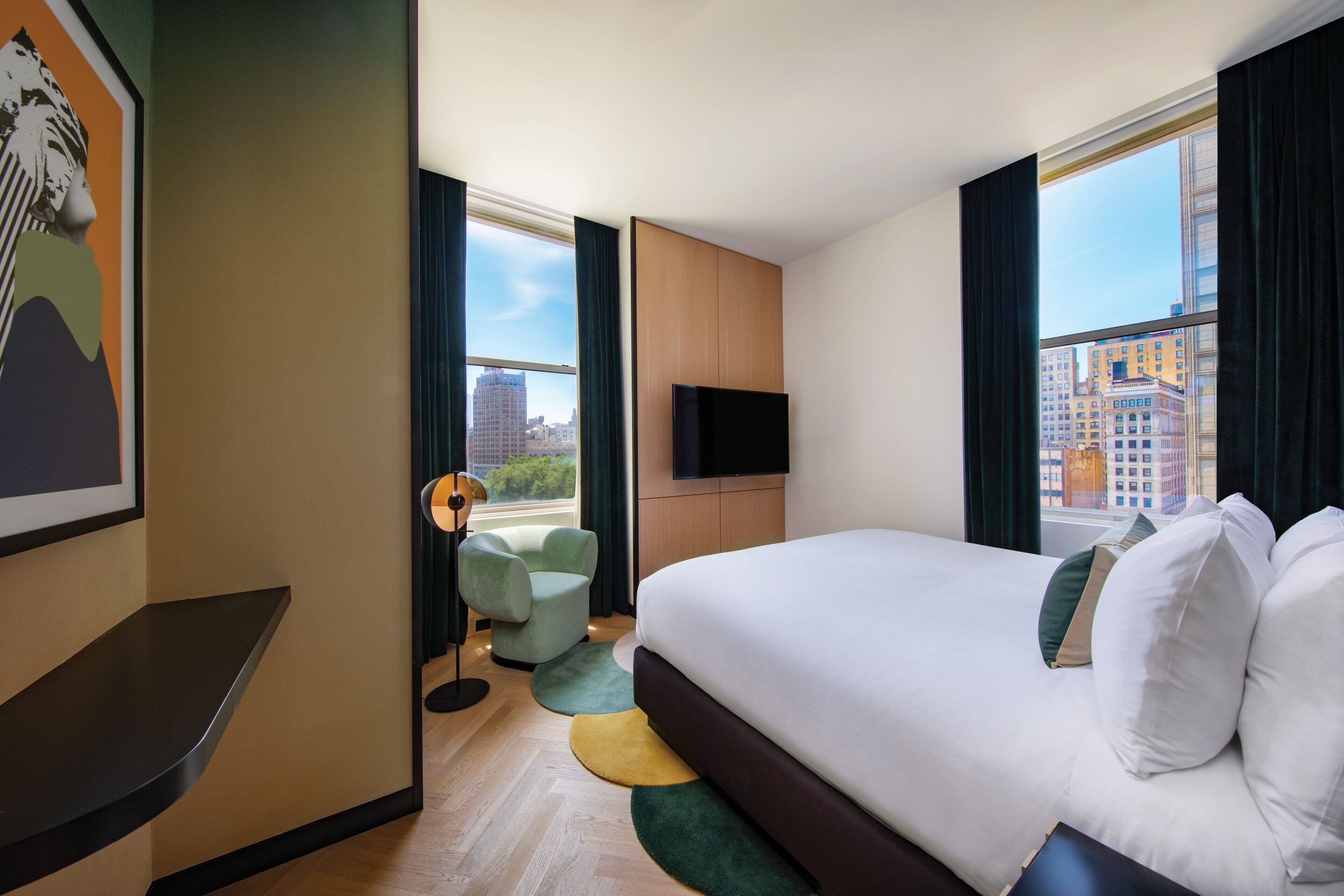 A hotel room with a large bed, a flat-screen TV, a desk, and a chair.