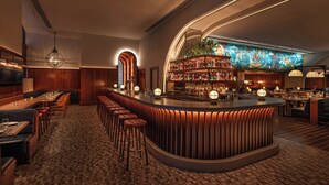 A bar area with a curved counter, stools, and a mural. - W New York - Union Square (New York)