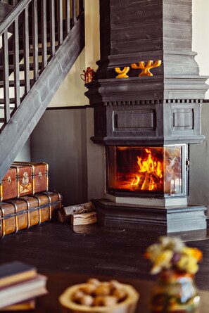 Cozy space with a large, open fireplace and vintage trunks.