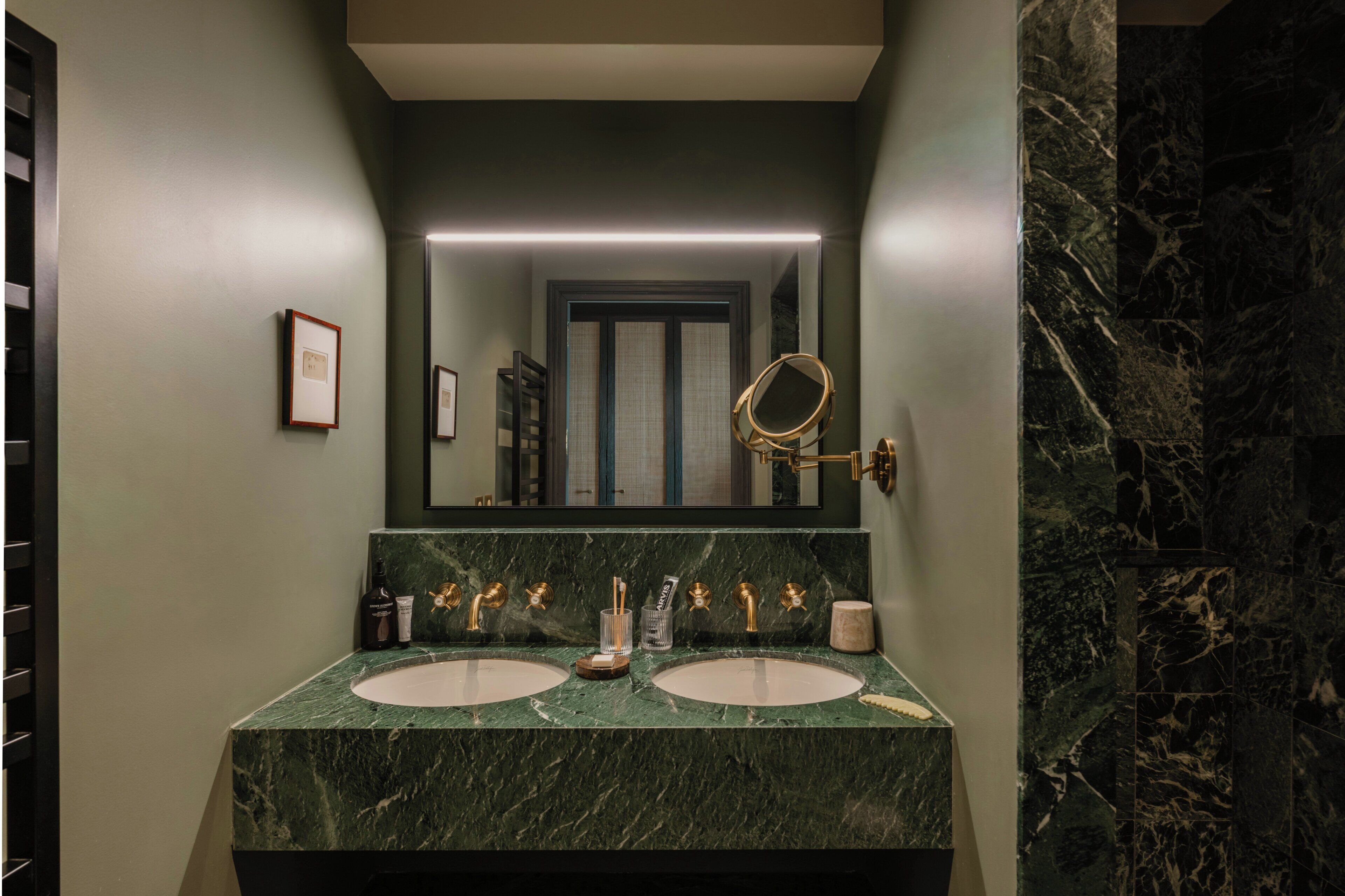 A bathroom with two sinks, a large mirror, and a marble countertop.