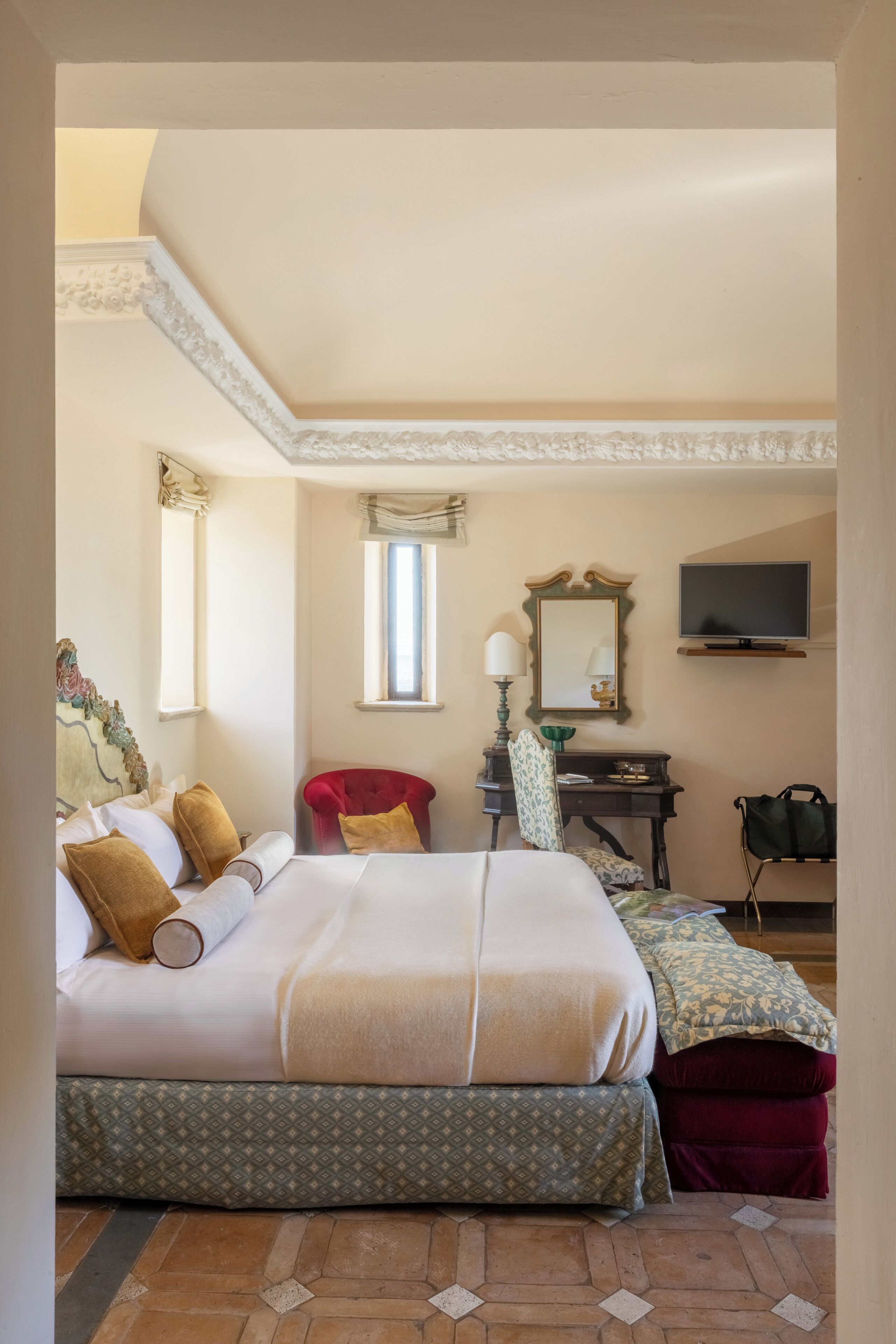 Un dormitorio con una cama, un escritorio, una silla, un televisor y una ventana.