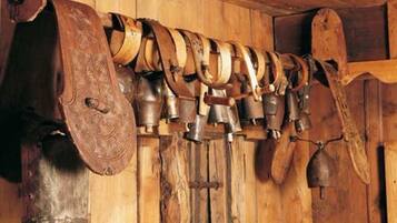 Un mur en bois orné d’une série de cloches, avec une grande cloche placée à gauche.