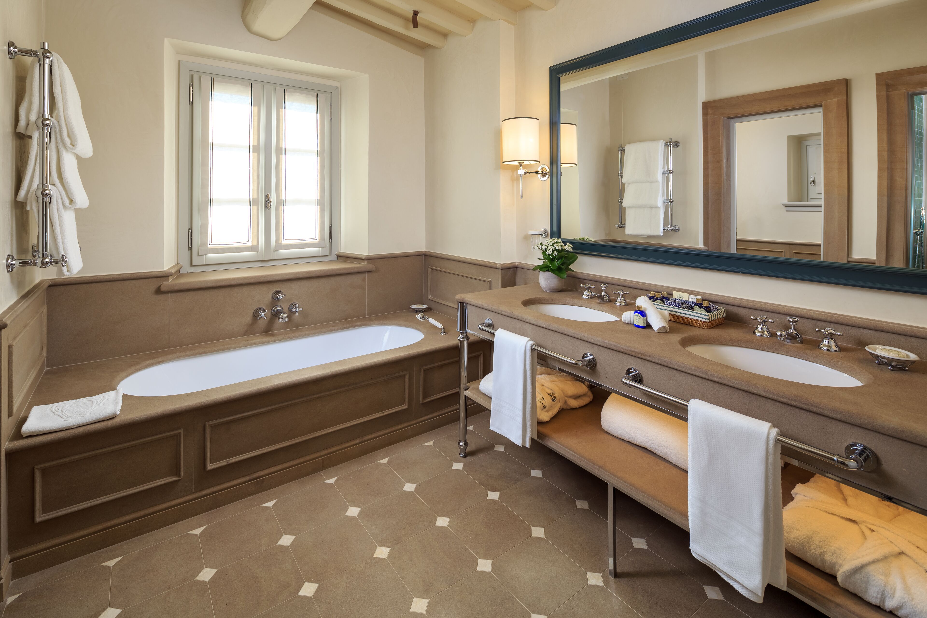 A bathroom with two sinks, a large bathtub, and a mirror.