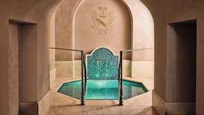 An arched entrance leading to a pool area with a decorative emblem on the wall. - Villa La Massa (Bagno a Ripoli)
