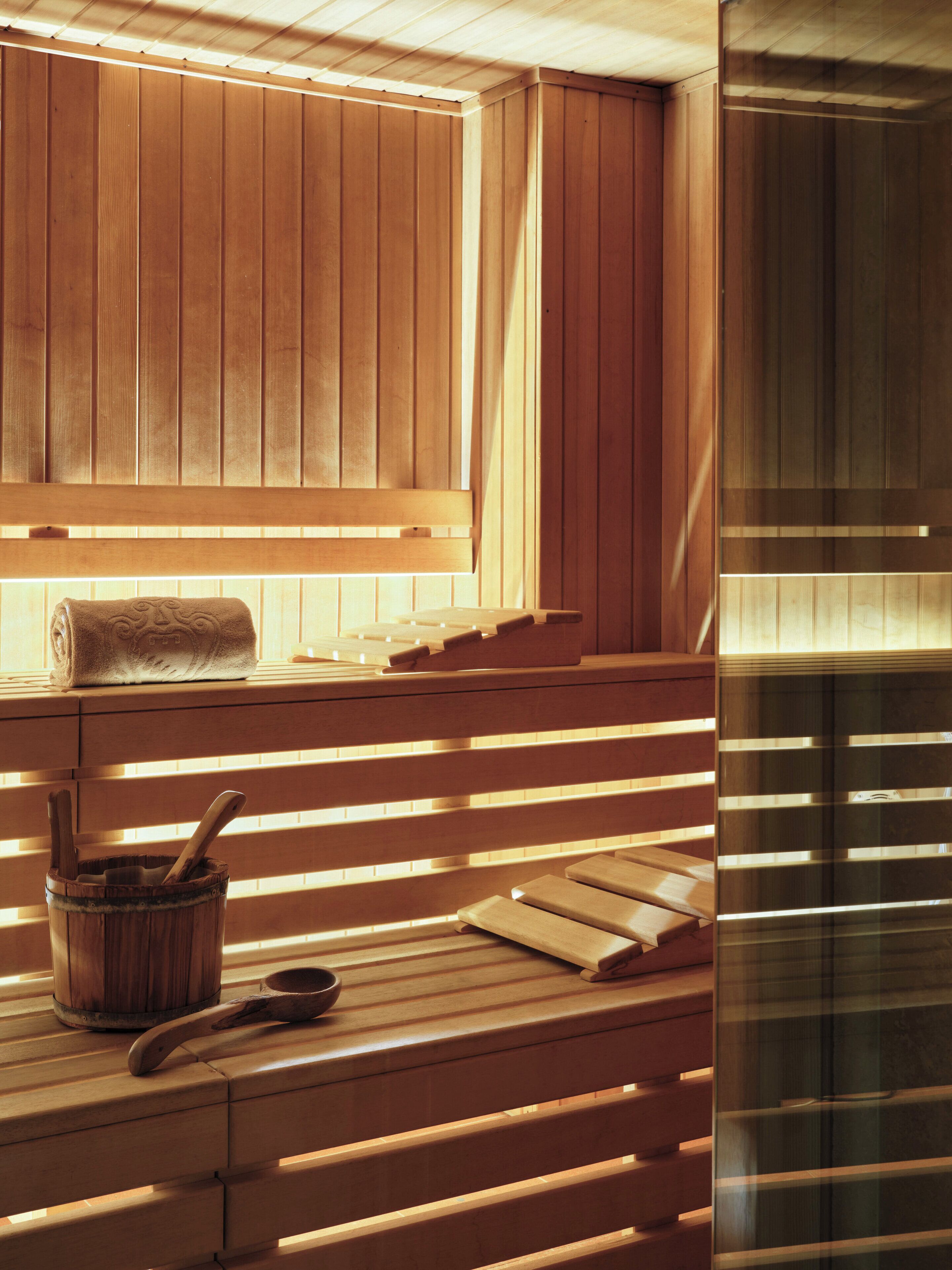 A wooden sauna with benches and a towel on the seat.