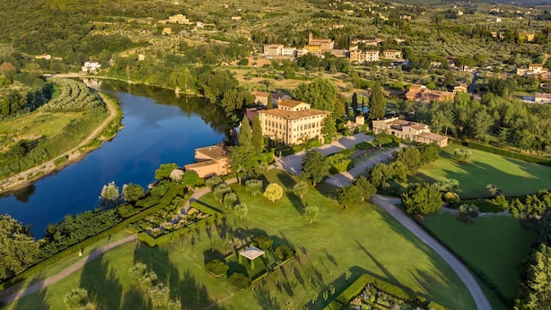 An aerial view of a town with a large lake, surrounded by greenery and hills. - Villa La Massa (Bagno a Ripoli)